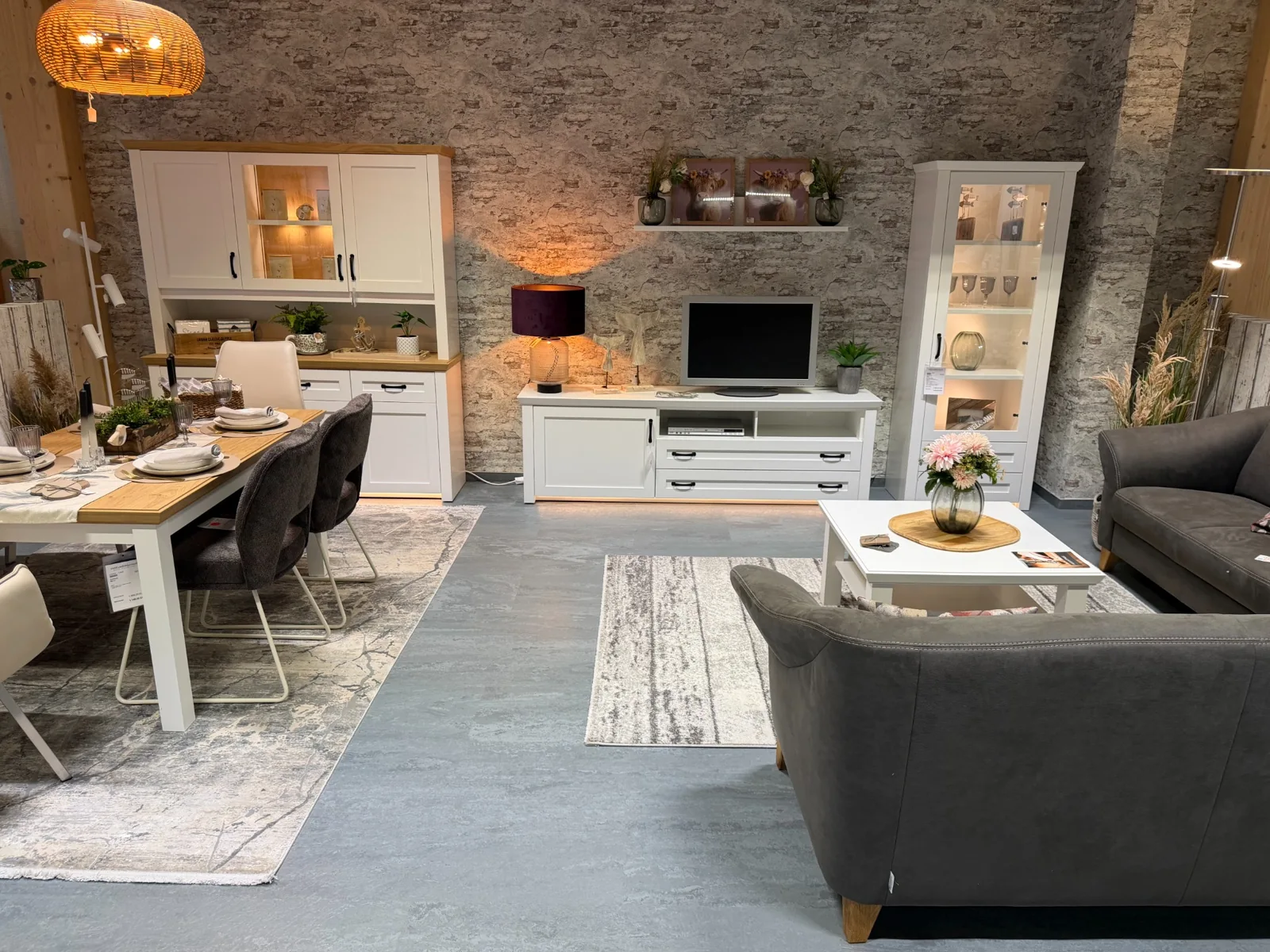 Weiße Vitrinen und Sideboard in einer gemütlichen Wohnsituation im Landhausstil