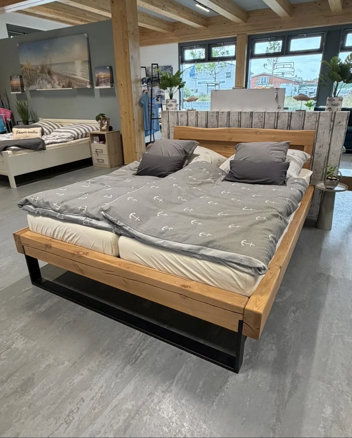 Bett mit Holzrahmen und grauer maritimer Bettwäsche im liege.platz auf Föhr